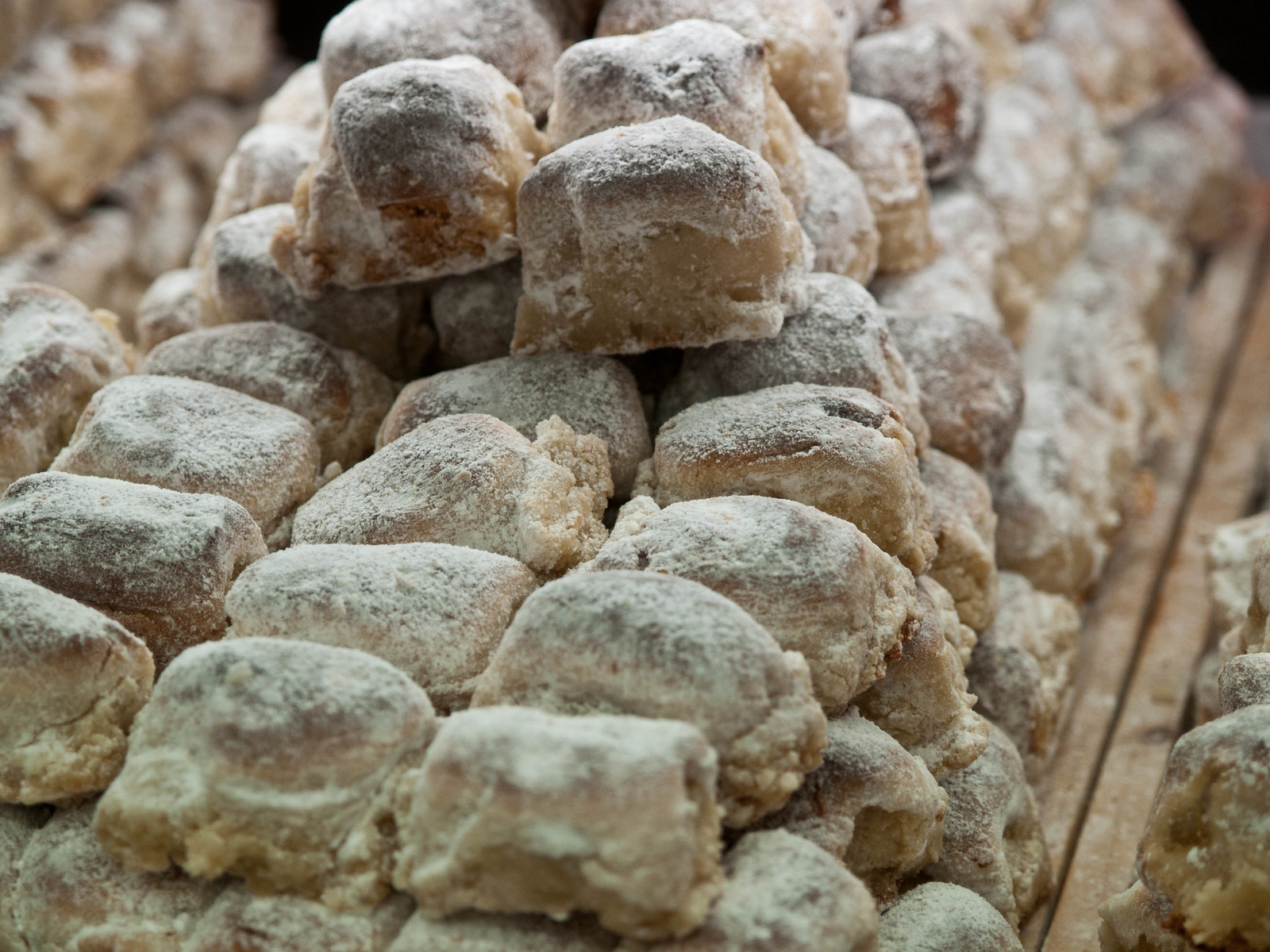 Biscotti siciliani chiari e irregolari ammucchiati su un banco
